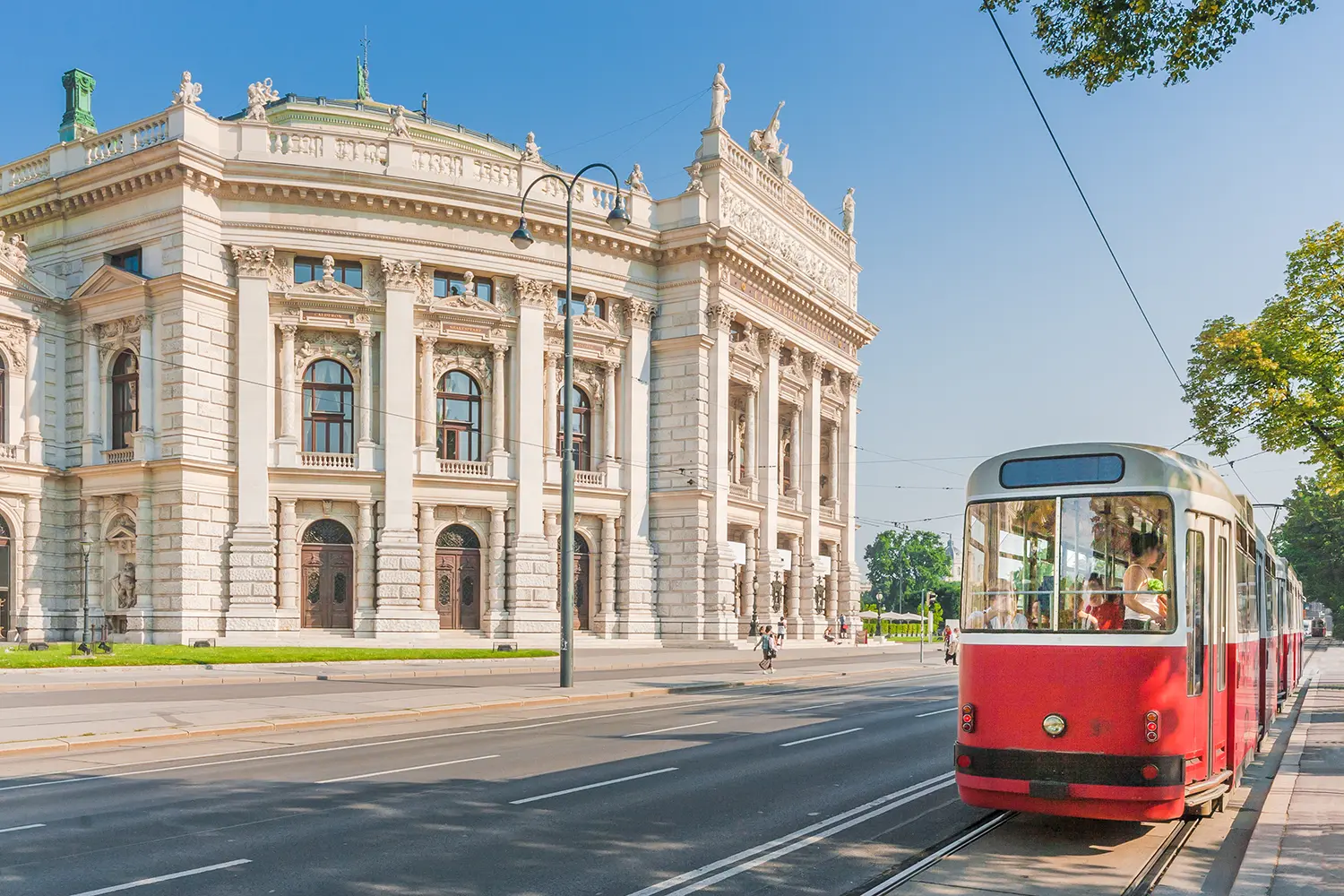 Famous Wiener Ringstrasse with historic Burgtheater (Imperial Court Theatre) and traditional red electric tram at sunset with retro vintage Instagram style filter effect in Vienna, Austria