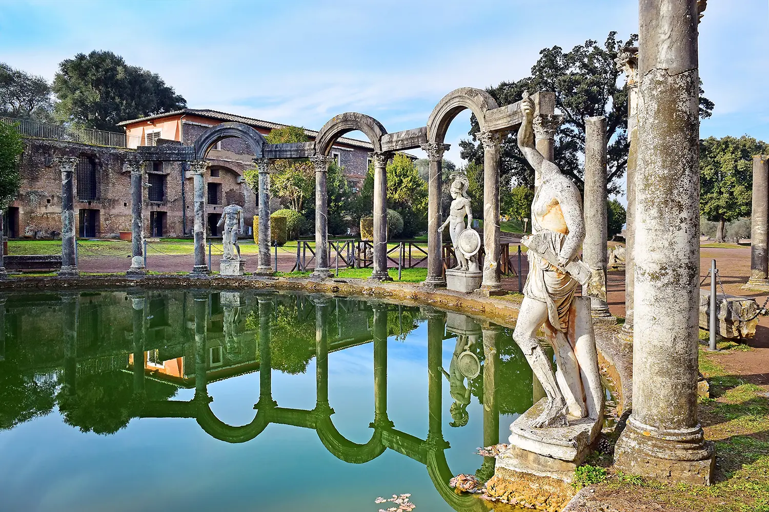 Ancient pool called Canopus, surrounded by greek sculptures in Villa Adriana (Hadrian's Villa) and reflections in water in Tivoli, Italy